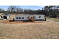 Single-wide manufactured home with a landscaped yard and detached shed at 87 Firemens Ln, Taylorsville, NC 28681