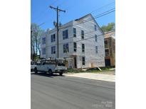Three story home with visible windows and construction wrap under a clear sky, showcasing the property's developing exterior at 111 Verbena Ne St # 10, Charlotte, NC 28217