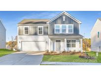 Two-story house with gray and white siding, a white garage door, and landscaping at 1715 Wooten Way, Bessemer City, NC 28016