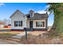 Charming renovated home with a white exterior, black roof, and inviting front entrance at 209 N Davis Ave, Newton, NC 28658