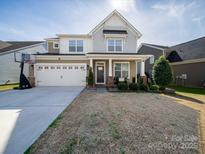 Charming two-story home showcasing a well-maintained lawn and a basketball hoop near the driveway at 222 Blossom Ridge Dr, Mooresville, NC 28117
