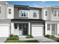 Two-story townhome with gray siding, white trim, and a two-car garage at 8016 Lerwick Trl, Charlotte, NC 28269