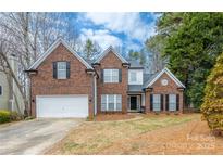 Charming two-story brick home with attached garage and well-maintained lawn at 8851 Glenside St, Huntersville, NC 28078