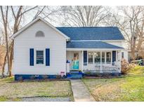 Charming home with a welcoming front porch, blue shutters and vibrant landscaping at 30 Hunter St, York, SC 29745