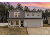 Charming two-story home with a covered porch and attached two car garage at 310 Black Rock School Rd, Cherryville, NC 28021