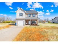 Inviting two-story home with vinyl siding, brick porch, attached garage and a well-maintained front yard at 425 Webb Rd, Shelby, NC 28152