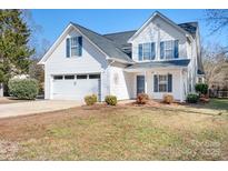 Charming two-story home with white siding, blue shutters, and attached two-car garage at 449 Doves Crest Ct, Stanley, NC 28164