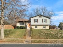 Charming two-story home featuring light siding, brick accents, and a well-maintained front lawn and inviting front entry at 7131 Thorncliff Dr, Charlotte, NC 28210