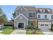 Two-story townhome with gray siding, two-car garage, and landscaped front yard at 11311 Magpie Ct # 2, Charlotte, NC 28215