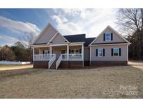 Charming home featuring a covered front porch and gray siding, located on a spacious lot at 2364 Valley Meadows Dr, York, SC 29745