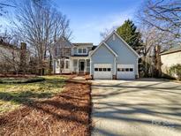 Two-story house with light blue siding, two-car garage, and a well-maintained lawn at 2650 Whisper Ridge Ln, Matthews, NC 28105
