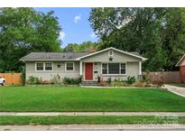 Charming single-story home featuring a well-manicured lawn and a welcoming red front door at 3949 Fieldcrest Rd, Charlotte, NC 28217