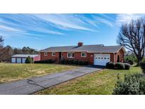 Charming brick home with a well-manicured lawn, long driveway, and detached garage at 63 Wagner Rd, Taylorsville, NC 28681