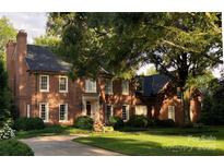 Stately brick home with manicured lawn, mature trees and circular driveway at 641 Museum Dr, Charlotte, NC 28207