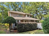 Charming home with mature landscaping and a welcoming covered porch at 6717 Paces Ferry Ln, Charlotte, NC 28226