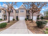 Charming townhome featuring a one-car garage, driveway, and well-maintained landscaping at 7719 Abigail Glen Dr, Charlotte, NC 28212