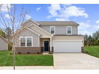 Charming two-story home boasts a manicured lawn and attached two-car garage, perfect for families seeking comfort and style at 821 Hallman Branch Ln, Lincolnton, NC 28092