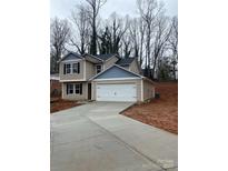 Two-story house with a gray and blue exterior, two-car garage, and a long driveway at 917 W Sumter St, Shelby, NC 28150