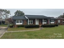 Charming brick ranch-style home with a covered porch and well-maintained landscaping at 1735 Hollandale Dr, Gastonia, NC 28054