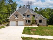 Stunning brick two-story home with a two car garage, beautiful landscaping, and charming architectural details at 2418 Lexington Approach Dr, Charlotte, NC 28262