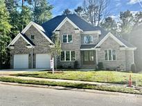 Attractive brick home with a two-car garage, manicured lawn, and large windows, creating curb appeal at 2418 Lexington Approach Dr, Charlotte, NC 28262