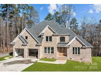 Beautiful brick home with an attached two-car garage and a well-manicured lawn at 2418 Lexington Approach Dr, Charlotte, NC 28262