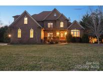 Charming brick two-story home with a beautifully landscaped front yard and inviting front porch at 2553 Cozy Cove Dr, York, SC 29745