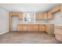 Bright kitchen features new wooden cabinets, a new countertop, and a double window for natural light at 528 6Th St, Chester, SC 29706