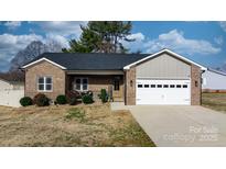 Charming brick home with a two-car garage, landscaped yard, and a welcoming front porch at 5324 Stonewood Dr, Hickory, NC 28602
