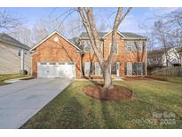 Charming two-story brick home with a well-manicured front yard and two car garage at 6245 Falls Lake Dr, Charlotte, NC 28270