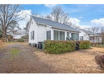 The side of the home shows the yard, siding and storm windows at 63 3Rd Nw St, Concord, NC 28027