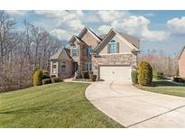 Stately stone and brick home with a manicured lawn and curved driveway, showcasing curb appeal at 9116 Arnsberg Dr, Waxhaw, NC 28173