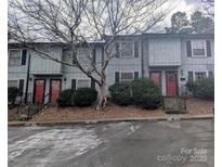 View of townhouse complex with muted exterior, red doors, and well-maintained landscaping at 115 Eastcliff Se Dr # 4, Concord, NC 28025