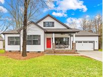 Charming home with red door, covered front porch and attached two car garage at 115 W Buckoak St, Stanley, NC 28164