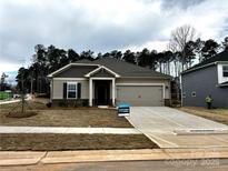 Charming single-story home boasts a welcoming facade, attached garage, and well-manicured landscaping at 1401 Windy Park Dr, Stanley, NC 28164
