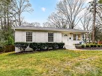 Charming one-story brick home with manicured landscaping and a well-maintained front yard at 3642 Litchfield Rd, Charlotte, NC 28211
