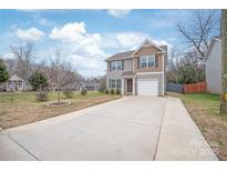 Charming two-story home features a long driveway and an attached garage at 610 John St, Monroe, NC 28110