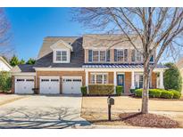 Charming brick home featuring a three-car garage and a well-manicured front lawn with mature trees at 658 Quicksilver Trl, Fort Mill, SC 29708