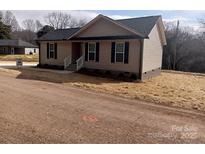 Charming single-story house with light brown siding and dark shutters, complemented by a well-maintained front yard at 67 Travora Cir, York, SC 29745