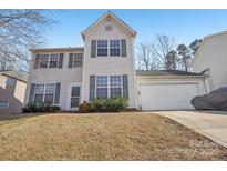 Charming two-story home with green shutters and a two-car garage, set on a well-maintained lot with mature trees at 10422 Baskerville Ave, Charlotte, NC 28269