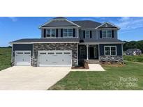 Charming two-story home featuring a stone facade, three-car garage, and manicured lawn against a bright sky at 1459 Mocksville Hwy # 19, Statesville, NC 28625