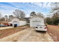 Charming single-story home featuring a well-kept lawn, attached garages, and a classic white facade at 307 W Mcneely Ave, Mooresville, NC 28115