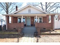 Charming brick home featuring a covered front porch with brick columns and a light blue front door at 604 Pearl Ave, Kannapolis, NC 28083