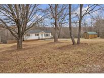 Charming single-story home with a well-maintained lawn, quaint porch, and outbuilding at 77 Timothy Dan Ln, Taylorsville, NC 28681