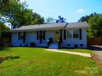 Charming single-story home with a well-maintained lawn and a welcoming yellow front door at 101 Colony Acres Dr, Charlotte, NC 28217