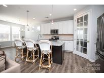 Bright, open kitchen featuring granite island with seating, and stainless steel refrigerator at 108 Hillston Ln, Mooresville, NC 28115