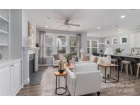 Bright living room featuring a fireplace, ceiling fan and a view to the dining and kitchen area at 108 Hillston Ln, Mooresville, NC 28115
