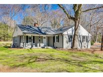 Charming single-story home with a gray brick facade, inviting front porch, and mature trees in a lush, green yard at 2478 Stribling Cir, Lancaster, SC 29720