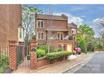 Charming brick townhome featuring a gated entrance, balcony, and a one-car garage, nestled in a desirable community at 309 Settlers Ln, Charlotte, NC 28202