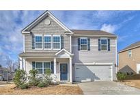 Charming two-story home features a covered entryway, light gray siding, and an attached two-car garage at 4010 Richard Andrew Dr, Matthews, NC 28105